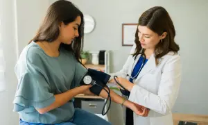 Lekarka zakłada mankiet do pomiaru ciśnienia pacjentce. To ważny etap diagnostyki, często poprzedzający skierowanie do specjalisty.