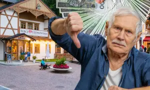 Starszy pan pokazuje kciuk w dół, trzymając stos banknotów. W tle budynek "Serce Uzdrowiska" w Szczawnicy.