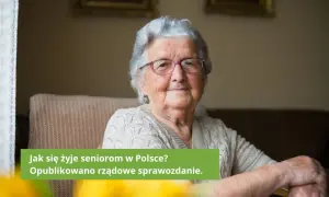 Uśmiechnięta starsza kobieta w okularach siedzi w fotelu.
