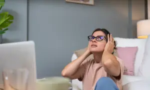 Kobieta z okularami zakrywa uszy, cierpiąc z powodu mizofonii. Dźwięki z otoczenia są dla niej nie do zniesienia.