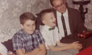 Wesoły chłopiec w muszce, jego brat i tata, tworzą uroczy zespół sawanta.