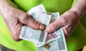Dłonie trzymają polskie banknoty: 10, 20 i 100 zł. Zastanawiasz się, ile wynosi renta socjalna?