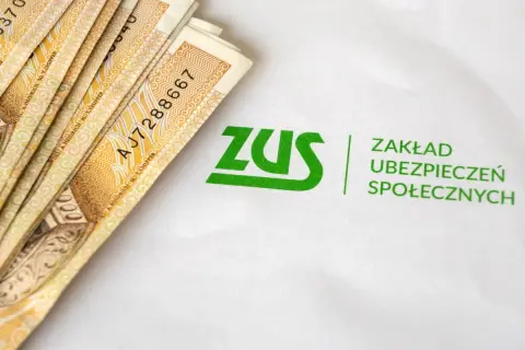 Pieniądze i logo ZUS. Symbolizują świadczenie rehabilitacyjne i wsparcie finansowe dla ubezpieczonych.