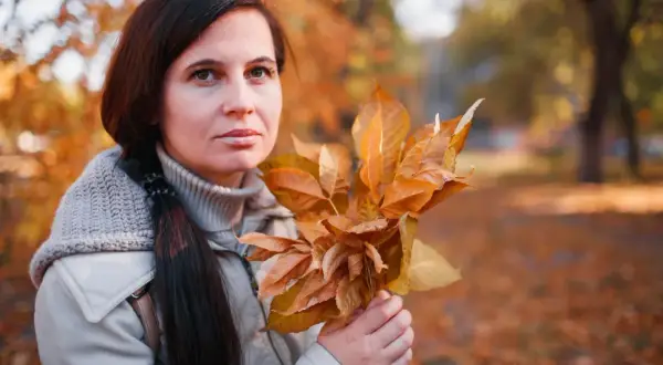 Chandra trzyma bukiet jesiennych liści, otoczona złotymi barwami parku.