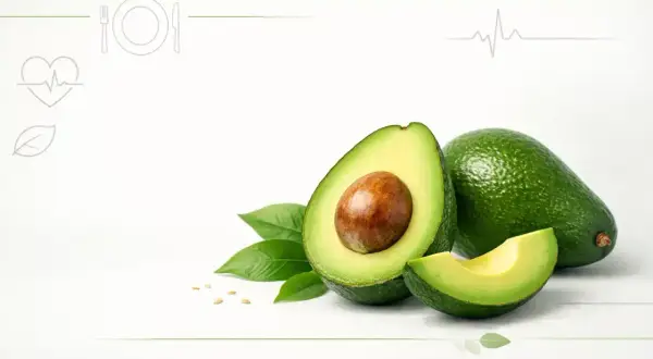 Dwa całe awokado, jedno przekrojone na pół z pestką, kawałek awokado i liście. Czy awokado jest zdrowe? Tak, to superfood!