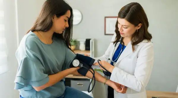 Lekarka zakłada mankiet do pomiaru ciśnienia pacjentce. To ważny etap diagnostyki, często poprzedzający skierowanie do specjalisty.