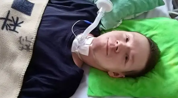 Chłopiec z chorobą DMD leży w łóżku, podłączony do respiratora.