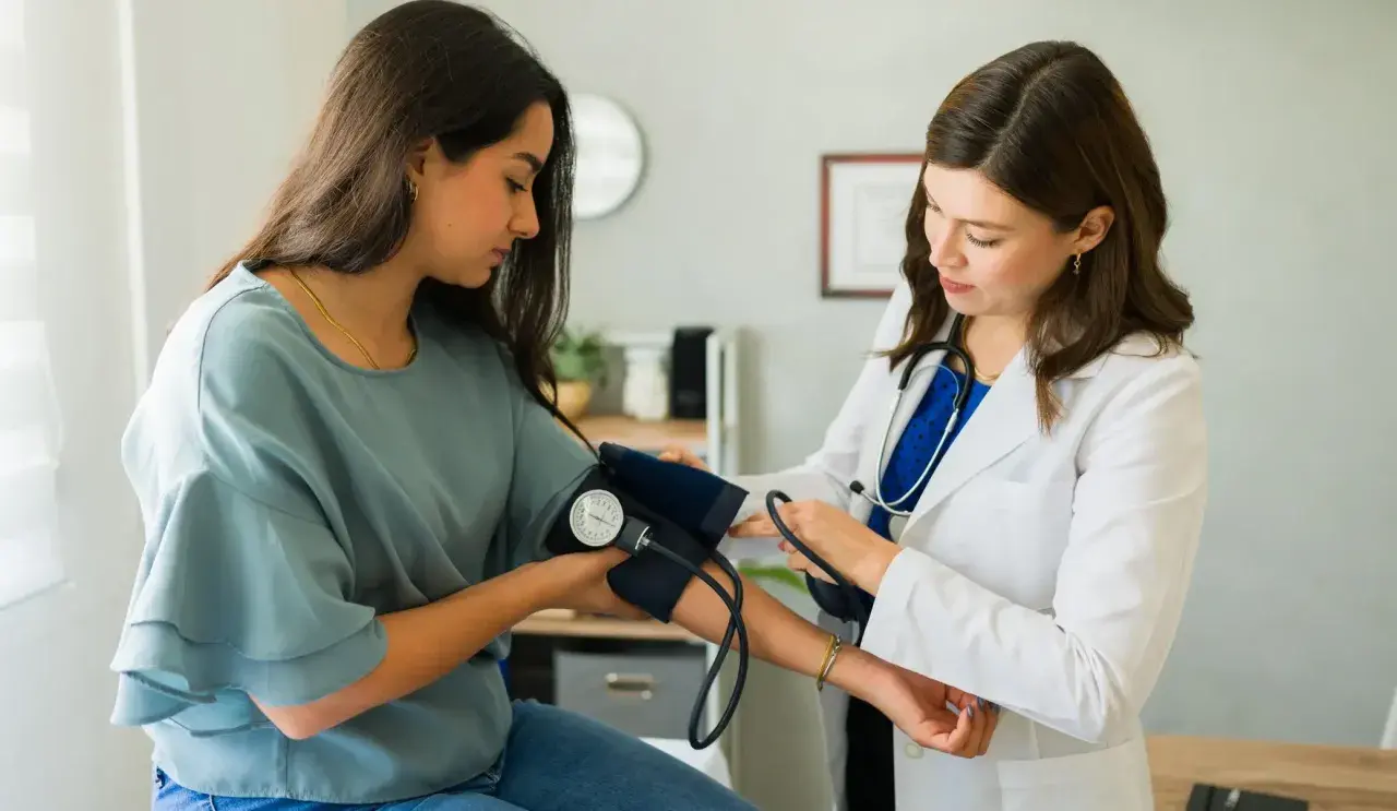 Lekarka zakłada mankiet do pomiaru ciśnienia pacjentce. To ważny etap diagnostyki, często poprzedzający skierowanie do specjalisty.