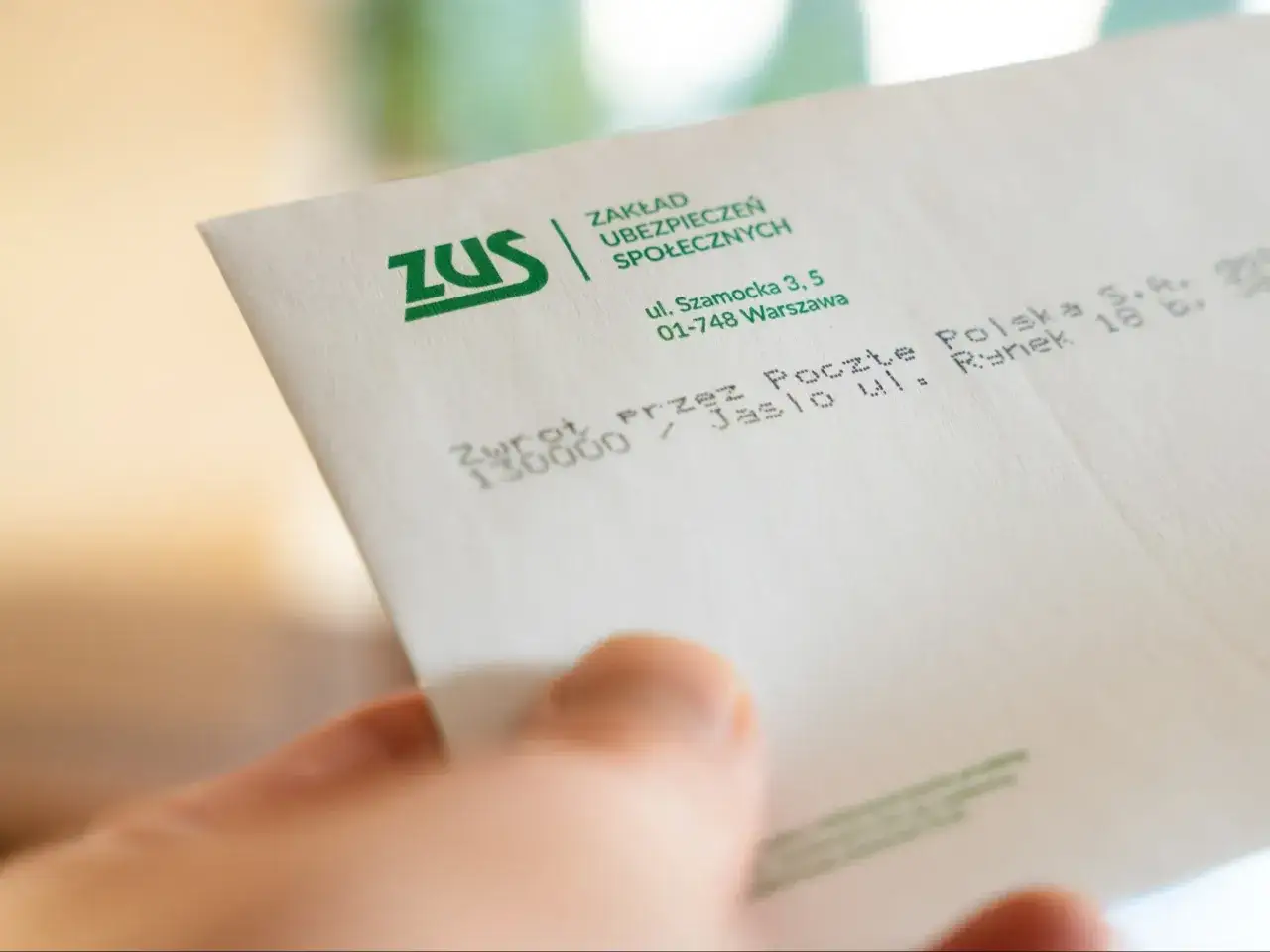 Koperta ZUS z adresem i stemplem. Może to być pismo dotyczące świadczeń, np. 500 plus dla niepełnosprawnych.