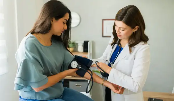 Lekarka zakłada mankiet do pomiaru ciśnienia pacjentce. To ważny etap diagnostyki, często poprzedzający skierowanie do specjalisty.